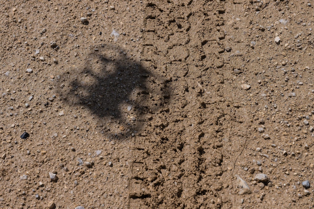 Schatten einer Drohne über Reifenspur